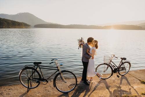 Paisagem com 2 psicadas e casal se beijando em frente ao Lago